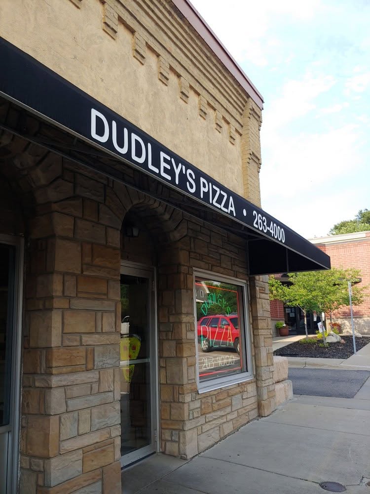 Dudley's Pizza entrance in Cannon Falls, black awning over the stone doorway.