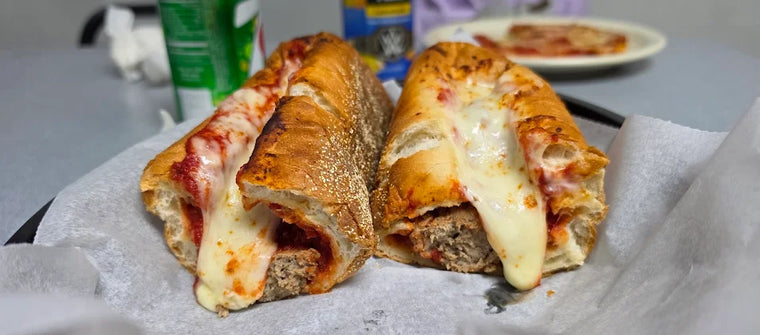 A toasted sub with melted mozzarella, cut in half in a basket at Dudley's Pizza in Cannon Falls